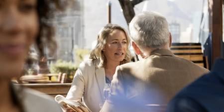 A man and woman sitting at a table having a conversation.